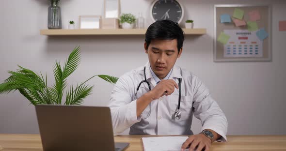 Male doctor cardiologist wearing white medical coat and stethoscope working in clinic alt