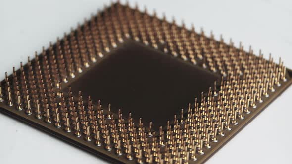 The Computer Processor CPU with Gold Plated Contacts Spins on White Background alt