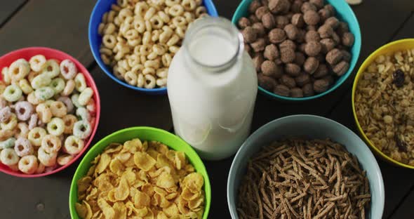 Video of cereals in colorful bowls on wooden kitchen worktop alt