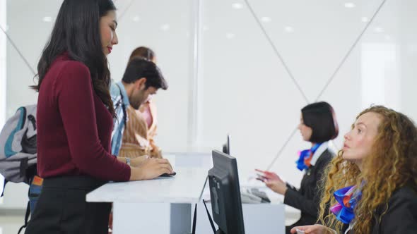 Asian traveler handing passport to airline staff at check in counter then received the ticket. alt