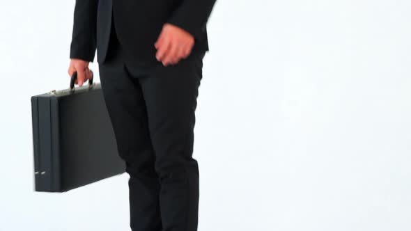 Businessman holding briefcase and shielding eyes alt