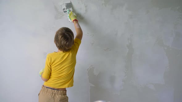 A Boy is Applying Putty to the Wall alt