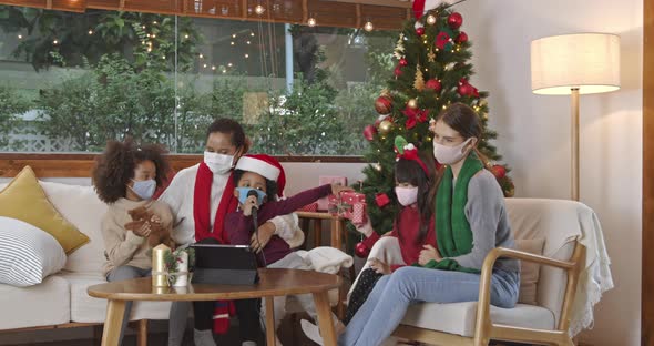Mothers with kids wearing masks singing celebrating Christmas at home
