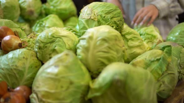 Woman Choosing Cabbage in Supermarket