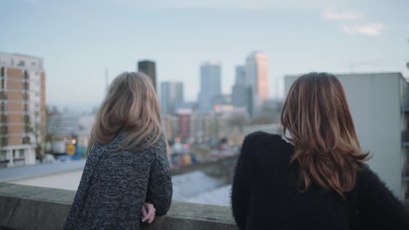 Young adult women looking out on rooftop