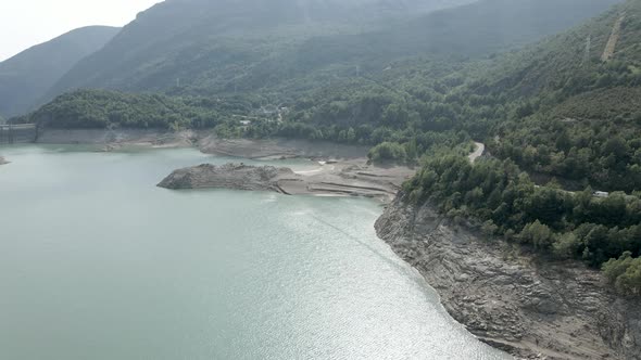 Aerial Drone View Over Reduced Water Levels of the Lake Ayous with the View of a Dam in the Distance alt