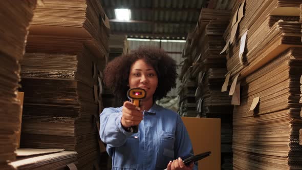 One female worker scan bar codes to check orders at parcels warehouse factory. alt