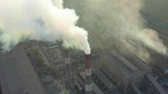 Industrial Zone with a Large Red and White Pipe Thick White Smoke Is Poured From the Factory Pipe in alt