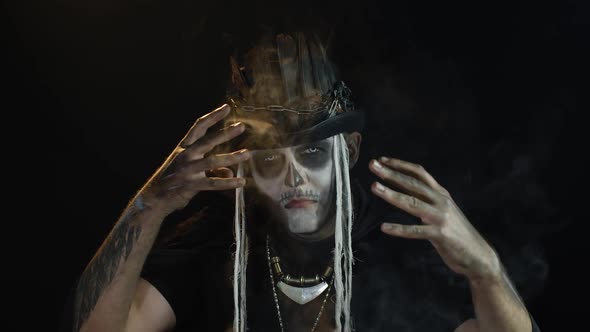 Creepy Man with Skeleton Makeup. Guy Exhaling Cigarette Smoking From His Mouth, Pointing at Camera alt