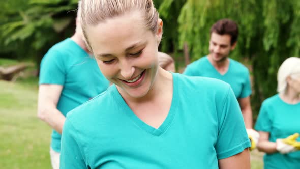 Female volunteer holding recycle bin in the park alt