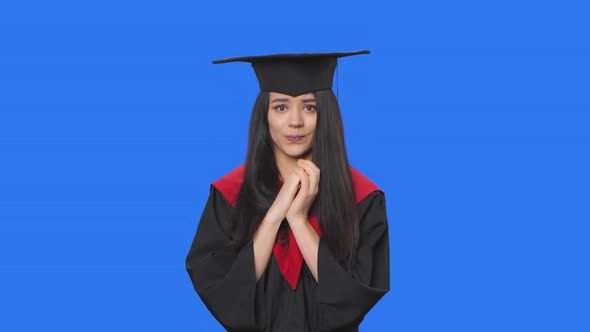 Portrait of Female Student in Graduation Costume Looking at Camera with Excitement Then Sighs in alt