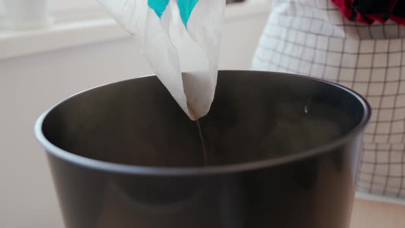 A Woman Pours Expanded Clay Into a Flower Pot alt