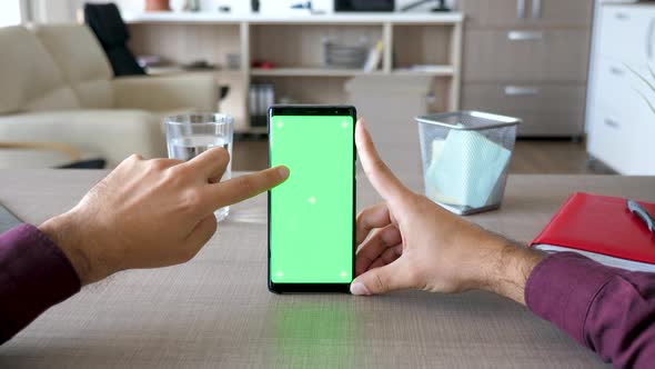 Man Touching Smartphone Screen with Chroma Mock Up on It alt