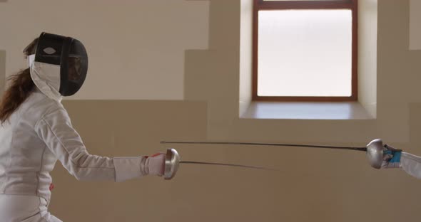 Fencer athletes during a fencing training in a gym alt