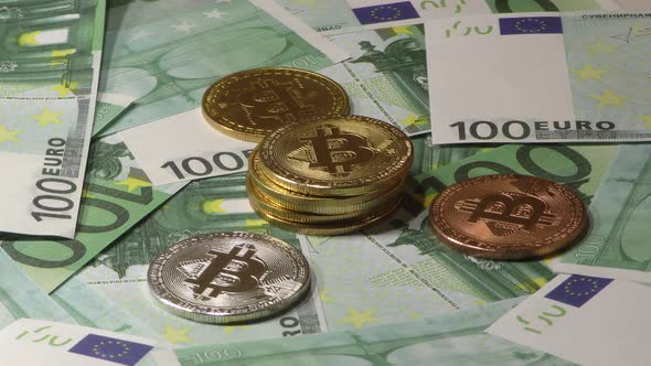 Gold Bit Coin BTC Coins Rotating on Bills of 100 Euro Banknotes. Worldwide Virtual Internet alt