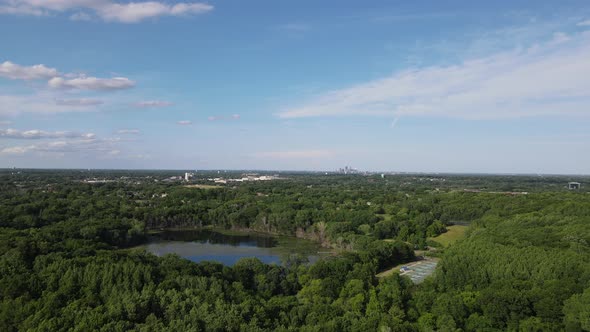 Aerial view over Lake Minnetonka with clear blue sky with wispy clouds and green foliage.