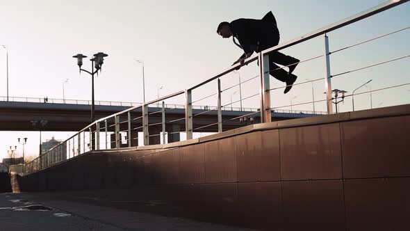 Businessman in Jacket and Tie Jumps Over an Obstacle on Background City alt