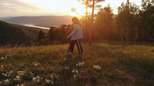 Happy Young Couple Walking on Mountain at Sunset alt