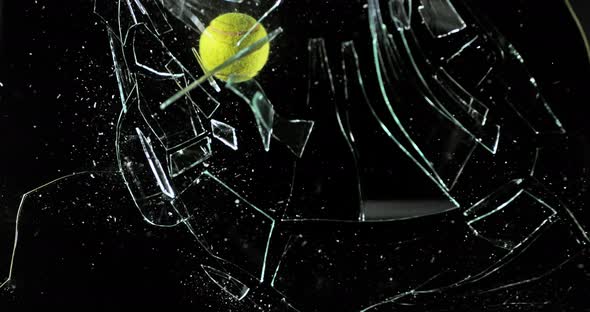 Tennis Ball breaking Pane of Glass against Black Background, Slow Motion 4K