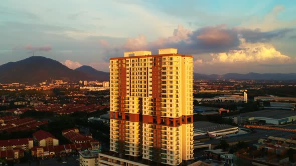 An aerial shot of high rise building surrounded by low rise homes during sunset. alt
