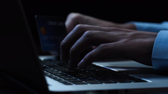 Hands of a man using laptop computer typing making payment online with credit card
