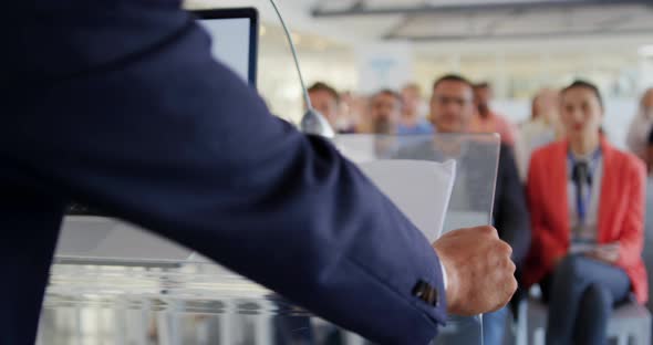 Male speaker addressing audience at a business conference alt