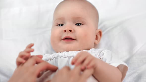 Closeup Hands of Mother Playing with Cute Baby in White Shirt Having Fun alt