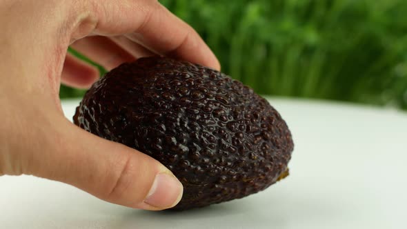 4K Video close-up Women s hands hold two cut halves of fresh Green Avocado alt