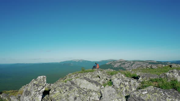 Aerial View of Young Traveller on the Mount Edge with Red Backpack