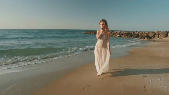 Romantic Blonde Girl Is Walking Alone on Sandy Beach in Summer Day, Moving Shot