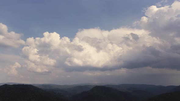 Aerial time lapse of developing clouds, over hills