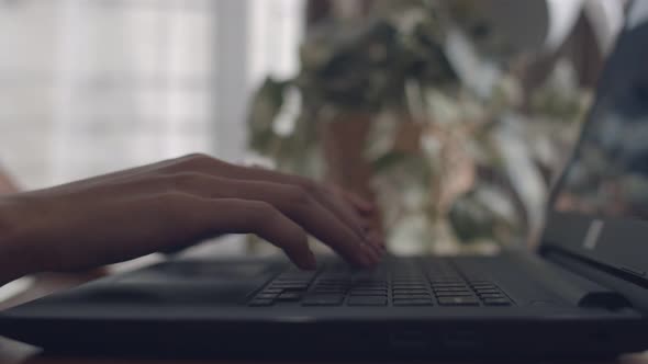 Close up of hands typing chatting on a laptop keyboard.