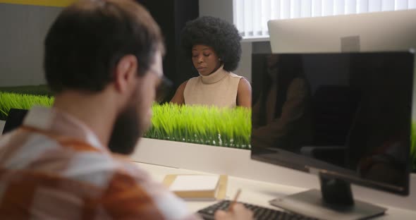 Multinational People Sit at Desks Working on Computers