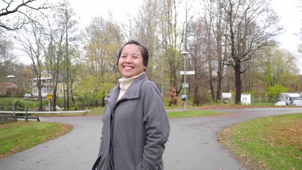 Happy Asian woman walking at park alt