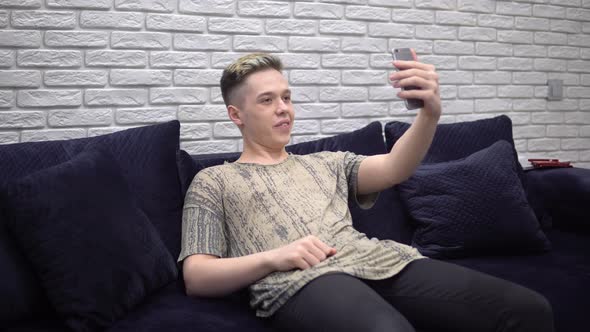 Man Talking By Video Chat Using Smartphone Dictance Studying Sitting on Sofa