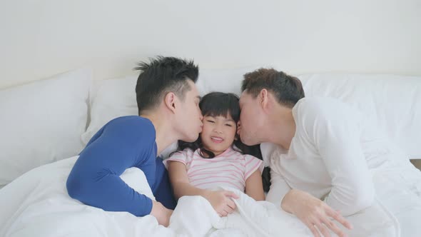 Portrait of handsome man gay family with young kid daughter in bedroom. alt