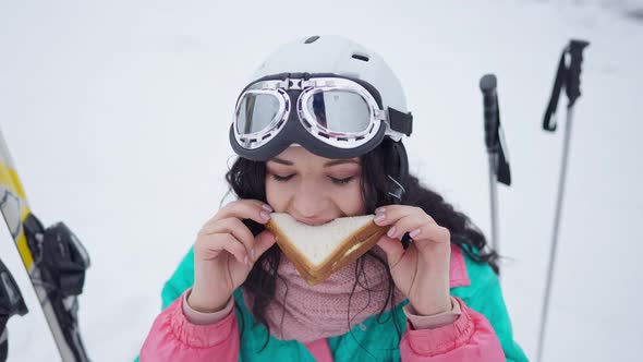 Portrait of Happy Woman Enjoying Tasty Sandwich at Winter Resort Outdoors alt