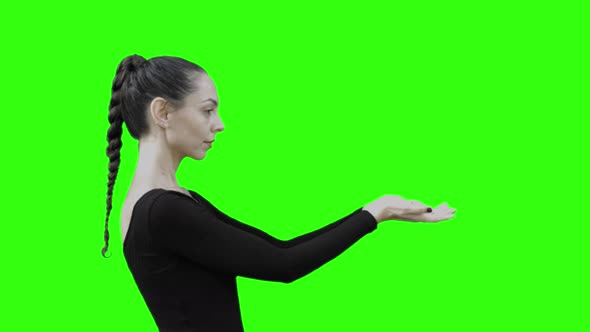 Young Woman looking at a Virtual Entity with Green Screen. alt