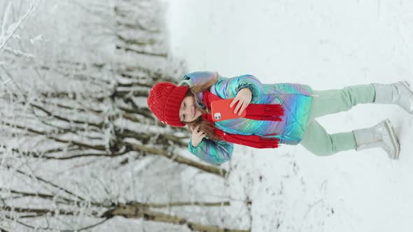 Vertical Video of Kid Girl Taking a Selfie Camera Shot by Smartphone in The Winter Forest