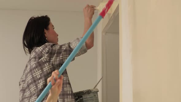 Female House Painters Paint the Walls in the Room.