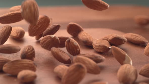 Almonds falling onto wooden surface in super slow motion.  Shot on Phantom Flex 4K high speed camera