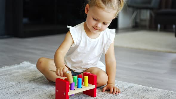 Cute Caucasian Little Girl Playing on the Floor at Home with Eco Wooden Toys alt