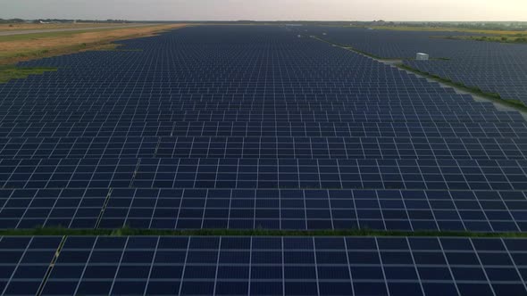 Drone Close Up Flies Over Large Solar Panels at a Solar Farm at Sunny Summer Evening alt