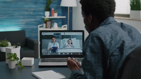 African American Dad on Internet Video Call Using Laptop alt