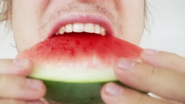 An Unshaven Caucasian Man Appetizingly Eats a Juicy Watermelon Closeup