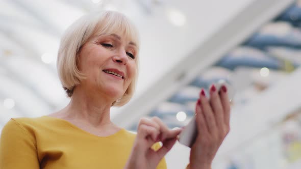 Closeup Happy Mature Woman Typing Friendly Message on Phone Checks Email Joyful Modern Grandmother alt