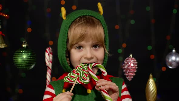 Child Kid Girl Christmas Elf Santa Claus Helper Costume Licking Candy Lollipop Caramel Sweets alt