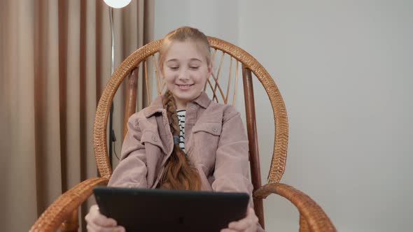 Girl Sitting with a Tablet in Her Hands