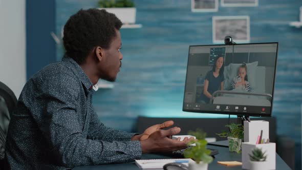 African American Man Talking with His Family Who is in Hospital Ward alt