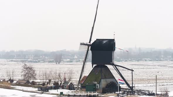 Dutch windmill producing clean energy drone shot. Retro rustic mill on a farm in the countryside. alt